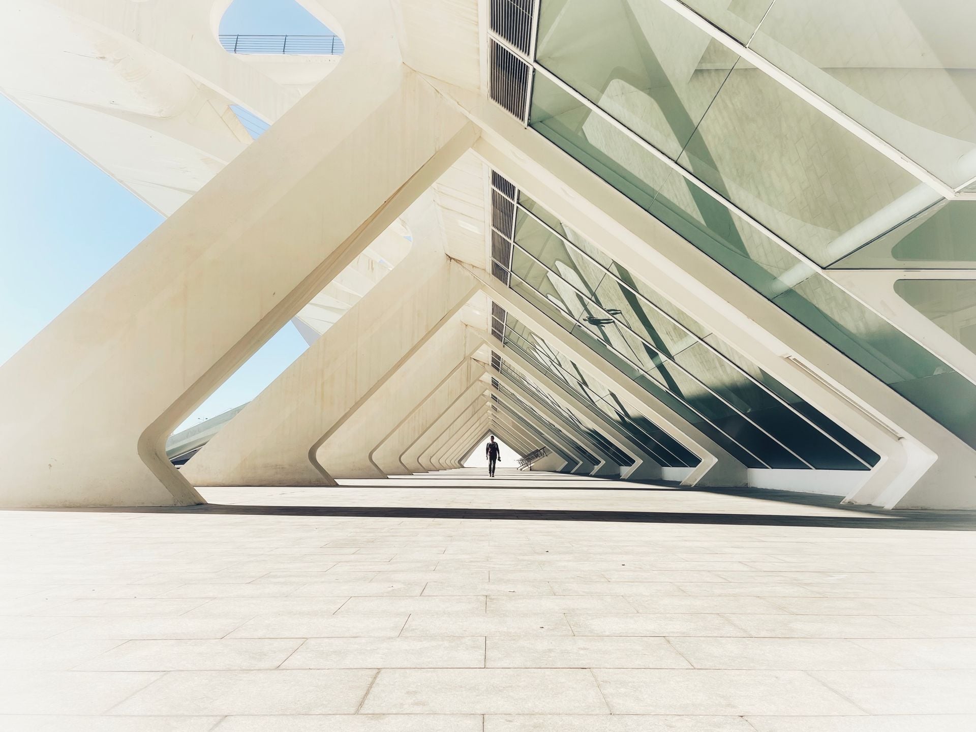 Angular glass architecture with a person walking through the passage